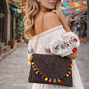 Chic Woven Shoulder Bag with Colorful Pom Poms